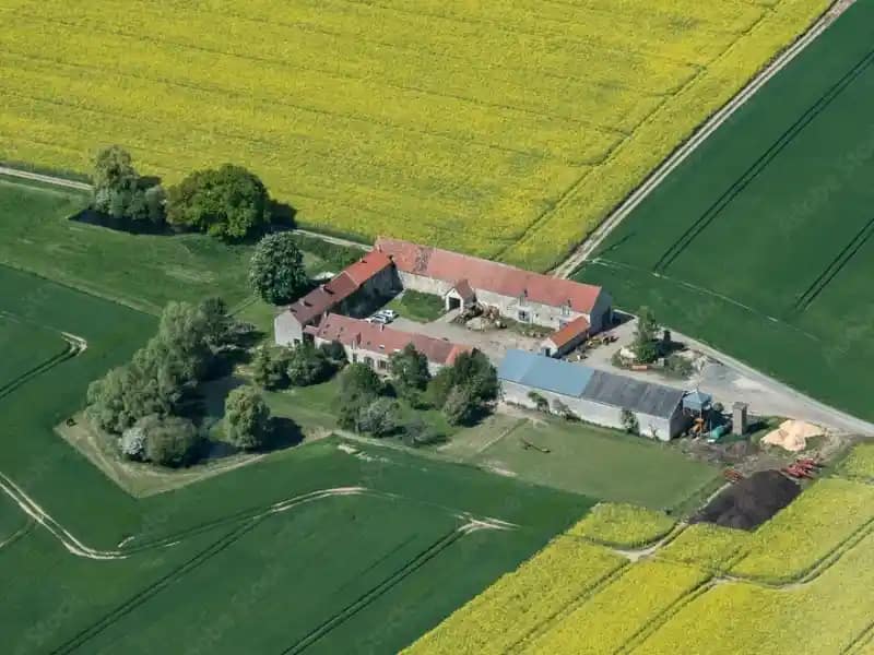 Vue aérienne d’un ancien corps de ferme pour patrimoine rural et agricole ancien