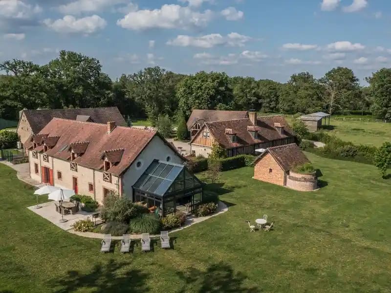 Vue aérienne d’un gîte touristique situé dans un environnement rural et naturel