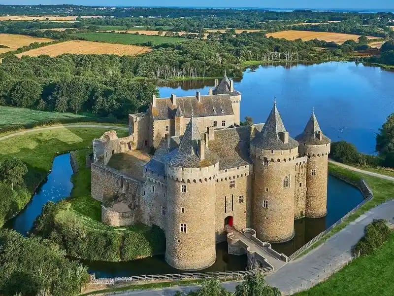 Vue aérienne d’un château de prestige entouré de douves et d’un vaste domaine
