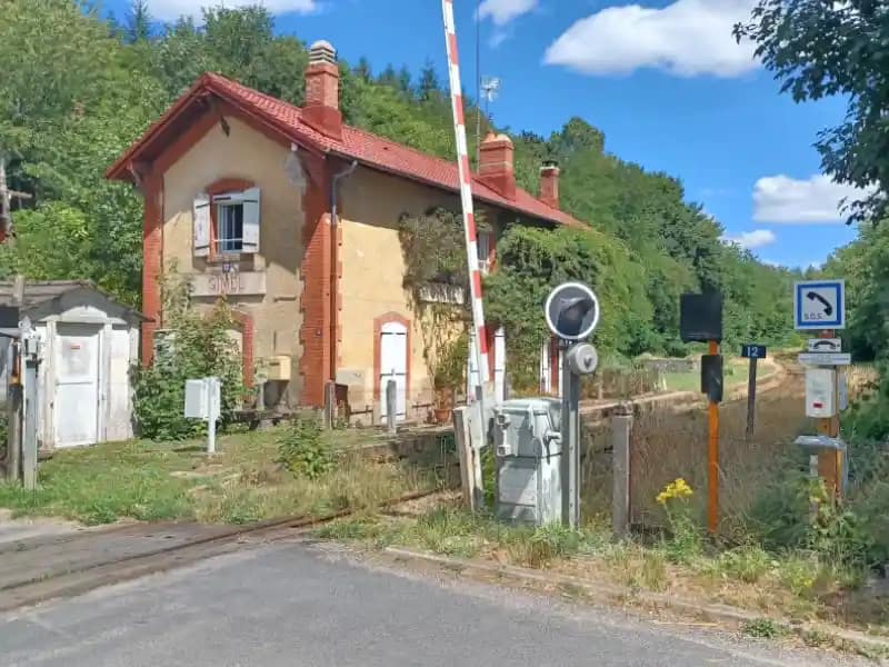 Gare et passage à niveau – Patrimoine ferroviaire local Ancienne gare et passage à niveau dans un environnement ferroviaire rural