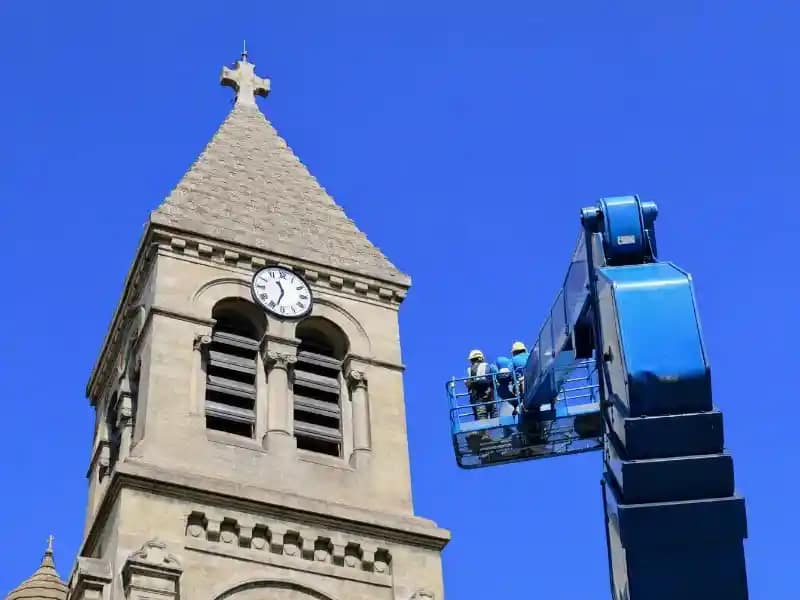 Observation aérienne du patrimoine rural Intervention sur un clocher illustrant les limites d'un accès traditionnel en hauteur.