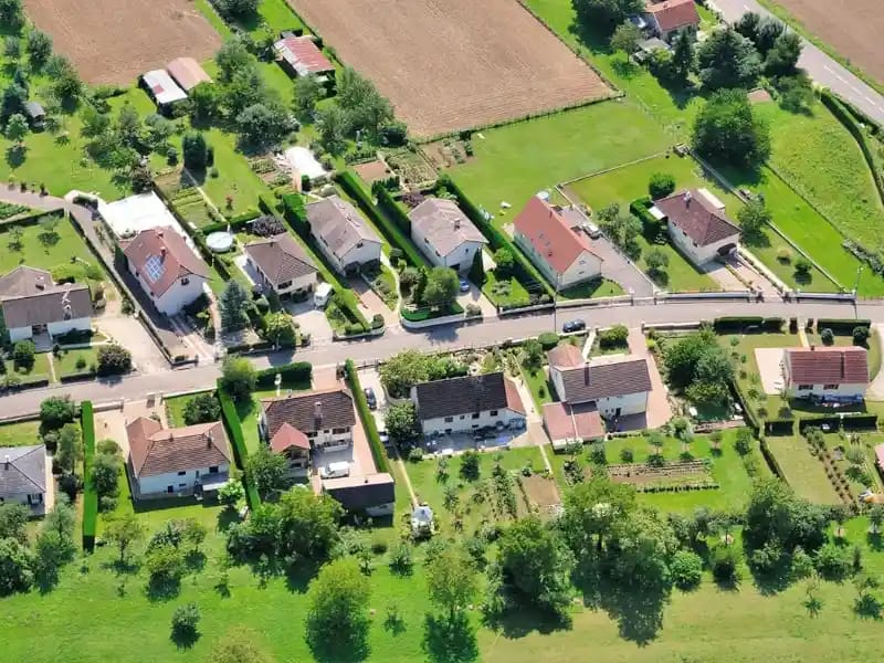 Maisons résidentielles implantées sur des parcelles avec jardins et terrains vues depuis les airs