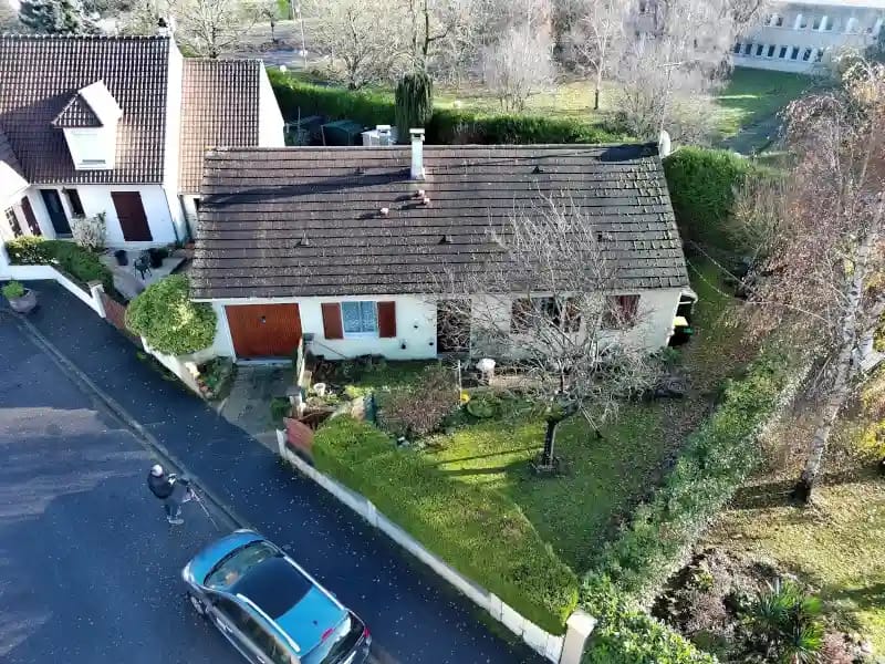 Télépilote réalisant une prise de vue aérienne d’une maison par drone