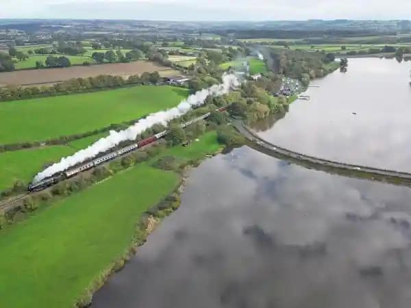 Ligne ferroviaire et train à vapeur vus du ciel Vue aérienne d’un train à vapeur circulant sur une ligne ferroviaire